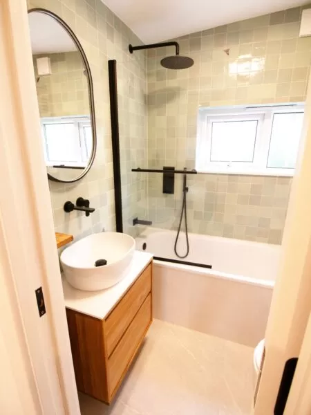 Small bathroom with vibrant turquoise zellige-style wall tiles. The rich colours add a lively touch, enhancing modern fixtures and creating a charming focal point.